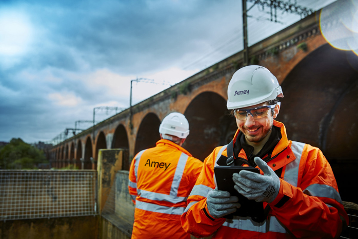 Two male Amey employees carrying out a bridge inspection