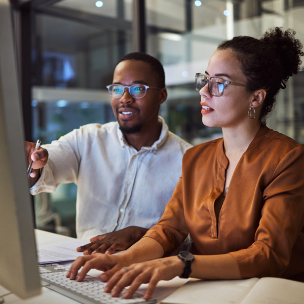 Image of two people working at computer
