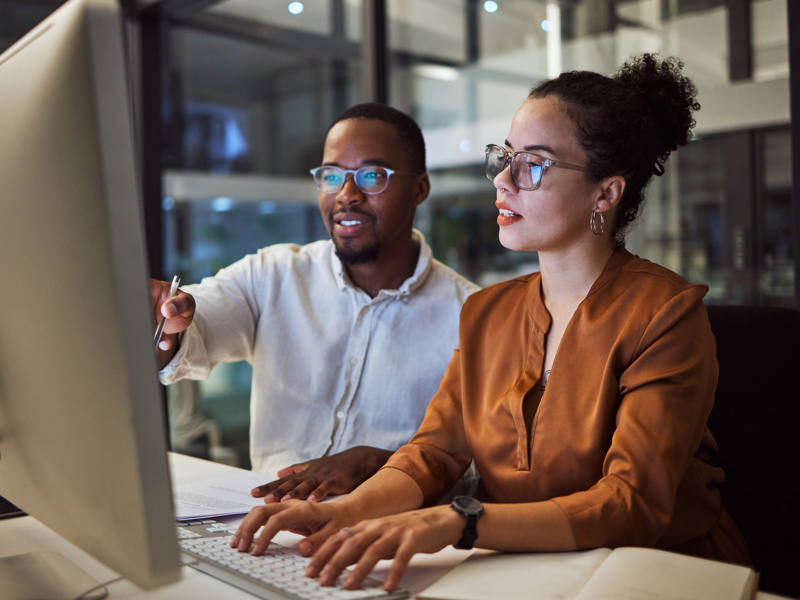 Image of two people working at computer